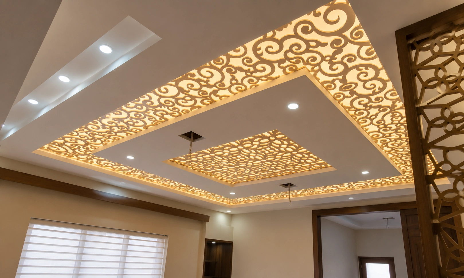 Decorative CNC false ceiling with laser-cut floral pattern and warm LED backlighting designed by False Ceiling Interior Designers in Trivandrum.