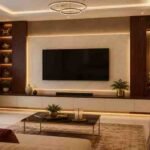 Modern TV unit design with a backlit marble feature wall and wooden showcase for a contemporary living room in Kerala.